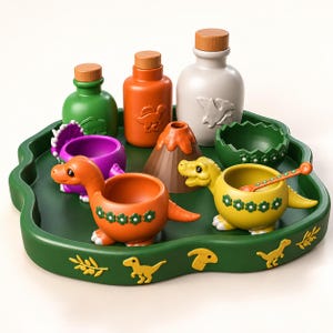 May include: A green tray with dinosaur-themed items including three bottles with wooden caps, a small volcano, a green egg-shaped bowl, and two dinosaur-shaped bowls in orange and yellow. The tray features yellow dinosaur and leaf motifs.