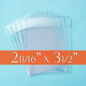 May include: Clear cellophane bags, stacked and fanned out, against a light blue background. The bags measure 2 11/16" x 3 1/2". The text "cellobags.etsy.com" is visible at the bottom.