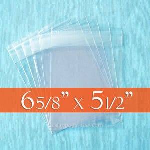 May include: Clear cellophane bags stacked on a light blue background. The bags are labeled with the dimensions 6 5/8" x 5 1/2". The bags are transparent and appear to be empty. The bags are likely for packaging small items.