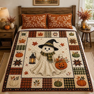 May include: A quilted bedspread featuring a central illustration of a ghost wearing a witch hat and scarf, holding a lantern and a pumpkin basket. The border consists of patchwork squares with autumn leaves, plaid patterns, and various pumpkins.