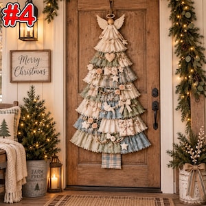 Könnte beinhalten: Ein Wandbehang in Form eines Weihnachtsbaums aus geschichtetem, gerüschtem Stoff in gedeckten Grün-, Blau- und Cremetönen. Der Baum ist mit einem Stoffengel gekrönt und mit kleinen Stoffherzen, Sternen, Schleifen und einem Geschenk verziert.