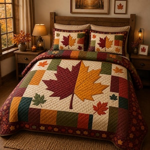 Pode incluir: Uma colcha acolchoada e duas fronhas a condizer com um design de patchwork nas cores creme, bordeaux, verde azeitona e dourado. A roupa de cama apresenta grandes motivos de folhas de ácer e padrões de folhas mais pequenos no tecido.