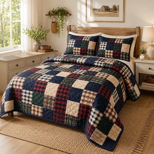 Può includere: Una trapunta patchwork e due federe abbinate con un motivo a griglia ripetuto di quadrati a quadri blu navy, verde bosco, crema e rossi. Il set da letto ha una consistenza trapuntata e copre un letto con una testiera in legno.