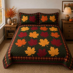May include: A dark green quilted bedspread and two matching pillow shams featuring a repeating pattern of appliqued maple leaves in shades of orange, yellow, and deep red. The bedding set includes a plaid border in matching autumn colours.