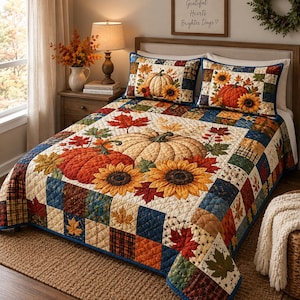 Puede incluir: Una colcha acolchada y dos fundas de almohada a juego con un diseño de patchwork de hojas de otoño, girasoles y calabazas en tonos naranja, amarillo, marrón y azul. La ropa de cama presenta un patrón de costura en forma de diamante.