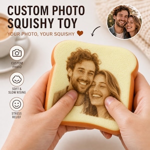 May include: A square-shaped, light yellow squishy toy shaped like a slice of bread, featuring a custom monochrome photographic print of a smiling couple on the front surface. The toy has a textured, porous appearance and rounded corners.
