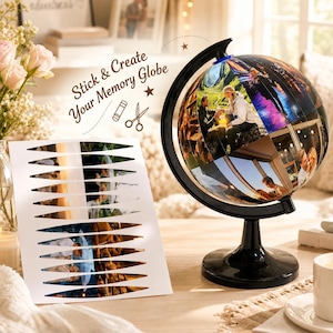 May include: A black globe stand with a spherical map covered in various personal photographs, accompanied by a white sheet featuring pre-cut, wedge-shaped photo stickers. The text Stick & Create Your Memory Globe is printed above the sheet.