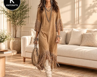 May include: A tan suede dress featuring three-quarter length sleeves with fringe trim, a matching fringe hemline, and a round neckline. The garment is accessorized with a layered chain necklace, beaded bracelets, and a matching tan suede handbag.