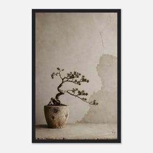 Puede incluir: Una impresión de arte mural enmarcada que muestra un pequeño bonsái retorcido plantado en una maceta beige texturizada y desgastada. El árbol tiene follaje oscuro y escaso y un tronco nudoso. El fondo es una pared neutra y moteada.
