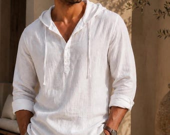 May include: A white long-sleeve hooded shirt with a button-down placket and drawstring ties, paired with light beige trousers. The shirt features a textured fabric, a relaxed fit, and sleeves that are rolled up to the elbows, revealing a brown watch.
