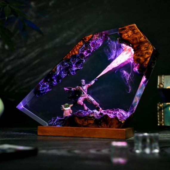 A hand-poured resin lamp encasing a Mandalorian Bounty Hunter scene — glows like actual galactic ambiance and looks genuinely one-of-a-kind on a shelf.