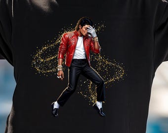 May include: A black short-sleeved t-shirt featuring a graphic print of a performer in a red leather jacket, white shirt, and black trousers, accented by gold glitter effects. The shirt is worn with bright pink sunglasses with reflective lenses.