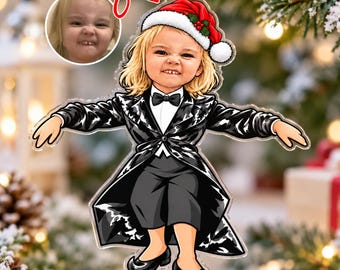 May include: A custom acrylic Christmas ornament featuring a cartoon illustration of a child with blonde hair wearing a Santa hat, a black tuxedo jacket, a white shirt with a black bow tie, black trousers, and black shoes, based on a photo.