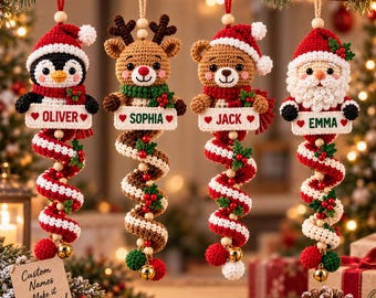 May include: Four crocheted Christmas ornaments featuring a penguin, reindeer, bear, and Santa Claus. Each character holds a white rectangular sign with the names Oliver, Sophia, Jack, and Emma, attached to a red and white spiral tail with bells.