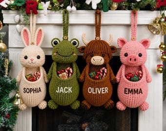 May include: Four crocheted animal stockings hang in a row, featuring a cream rabbit, green frog, brown highland cow, and pink pig. Each has a pouch containing small gifts and is personalized with the names Sophia, Jack, Oliver, and Emma.
