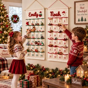 May include: Two off-white fabric advent calendars hanging on a wall, each featuring twenty-four numbered pockets with red trim. One calendar is personalised with the name Emily and a snowman, the other with Noah and a Santa face, both with wooden rods.