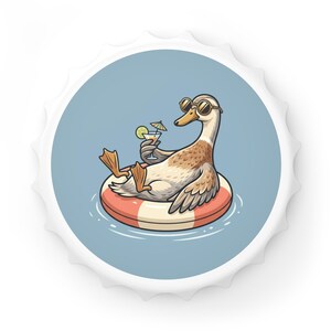 Könnte beinhalten: Ein runder Kronkorken mit einer grafischen Illustration einer braun-weißen Ente mit runder Sonnenbrille. Die Ente schwimmt auf einem rot-weiß gestreiften Schwimmring in blauem Wasser und hält ein Cocktailglas mit einer Limettenscheibe.
