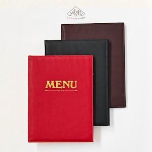 May include: Three rectangular menu covers in red, black, and dark brown. The red cover features the word MENU in gold lettering with a decorative line underneath. The ANNAMMADE logo is printed in black at the top center of the white background.