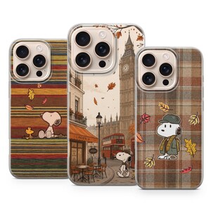 Può includere: Tre cover per smartphone con Snoopy e Woodstock. La cover a sinistra presenta strisce orizzontali e foglie autunnali. Quella centrale raffigura una strada di Londra con il Big Ben, un autobus rosso e Snoopy. Quella a destra ha un motivo scozzese.