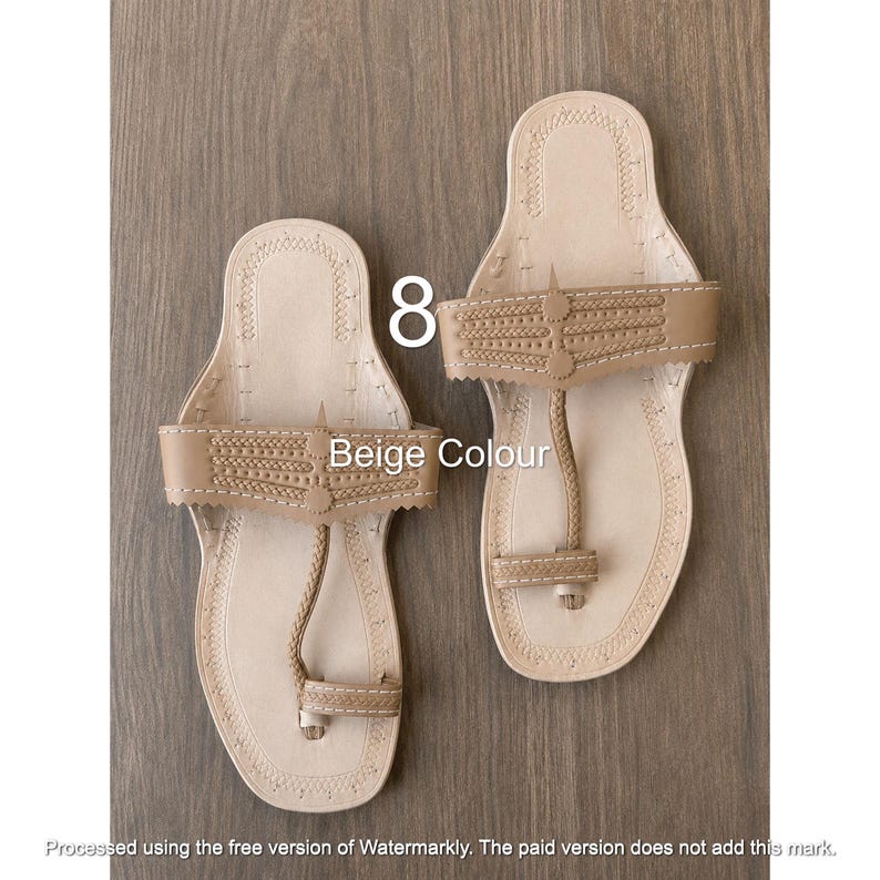 Op de afbeelding: Een paar beige leren sandalen met een teenstuk, een brede horizontale band met decoratieve stiksels en een platte zool. De tekst 8 en Beige Colour zijn zichtbaar op de afbeelding. De sandalen hebben een lichte kleur en een eenvoudig ontwerp.