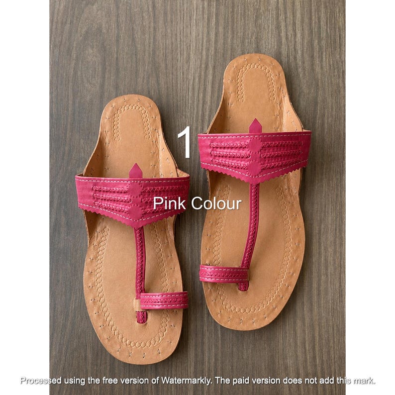 Op de afbeelding: Een paar roze sandalen met een beige leren voetbed en decoratieve stiksels langs de randen. De sandalen hebben een brede band over de wreef met een gestructureerd patroon en een teenstuk. De tekst 1 Pink Colour is zichtbaar.