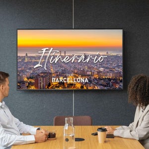 Può includere: Un grande schermo digitale montato a parete mostra un vivace paesaggio urbano di Barcellona al tramonto con il testo corsivo bianco Itinerario e il testo in stampatello PER BARCELLONA centrati sulla vista della città.