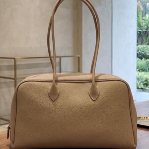 Sac cabas minimaliste en cuir grainé pour le travail au quotidien, porté épaule