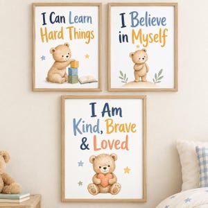 Puede incluir: Tres láminas decorativas enmarcadas con ositos de peluche en acuarela y frases motivadoras. Los cuadros muestran los textos I Can Learn Hard Things, I Believe in Myself y I Am Kind, Brave & Loved, junto a estrellas y pequeños objetos.