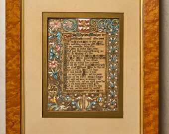 May include: A framed illuminated manuscript featuring black gothic calligraphy on parchment, surrounded by intricate floral and scrollwork borders in blue, pink, and gold. A red and white heraldic crest sits at the top, all encased in a burl wood frame.