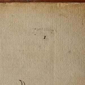 May include: A textured, off-white, aged paper surface featuring a small, black, printed number 1 centered in the upper portion. The paper displays visible fibers, subtle creases, and a dark, weathered edge along the top border of the frame.