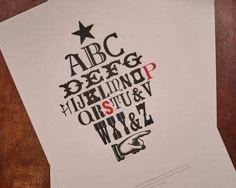 May include: A cream-colored paper print featuring a black star at the top, followed by the alphabet arranged in a triangular shape. The letters are in various black fonts, with the letters P and S printed in red. A black pointing hand icon is at the bottom.