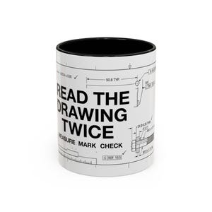 Peut inclure: Un mug en céramique blanche avec un intérieur noir, orné d'un dessin technique d'ingénierie noir. Le texte indique READ THE DRAWING TWICE et MEASURE MARK CHECK, accompagné de diverses dimensions techniques telles que 50.8 TYP et 25.4 ± 0.05.