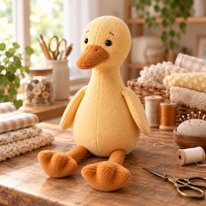 Pode incluir: Um brinquedo de pelúcia em forma de pato com um corpo amarelo macio, um bico laranja mais escuro e pés laranja correspondentes. O bicho de pelúcia apresenta olhos bordados simples e uma cabeça arredondada, sentado ereto com as pernas estendidas.
