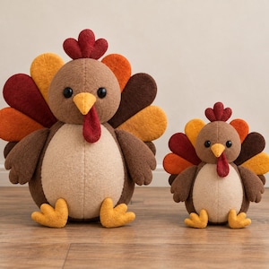 May include: Two felt turkey figures in different sizes, each featuring a brown body, a light beige chest, a yellow beak, a red wattle, and a fan-shaped tail with alternating red, orange, yellow, and dark brown rounded felt feathers.