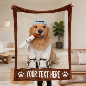 Könnte beinhalten: Eine rechteckige Fleecedecke mit dunkelbraunem Rand, die ein aufgedrucktes Bild eines Golden Retrievers mit hellblauer Baseballkappe, weißem T-Shirt und weißen Turnschuhen zeigt, der ein Spielzeug hält. Unten ist der Text "YOUR TEXT HERE" aufgedruckt.