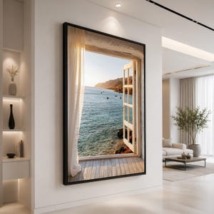 Könnte beinhalten: Ein rechteckiges Wandbild mit dem Motiv eines offenen Fensters, das den Blick auf einen ruhigen Ozean bei Sonnenuntergang freigibt. Die Szene umfasst eine Holzterrasse, halbtransparente weiße Vorhänge und ferne Berge unter klarem Himmel, eingefasst in einen schwarzen Rahmen.