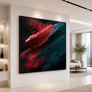May include: A large square wall art piece featuring a bold abstract composition of vibrant red and deep teal pigments against a dark black background, framed in a thin black border, displaying a textured, powder-like effect across the canvas.