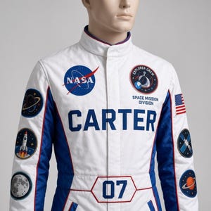 May include: A white and blue space-themed jumpsuit featuring the NASA logo, an Explorer Crew Space Mission Division patch, and the name CARTER in bold blue letters. The sleeves display various space patches, and the number 07 is printed on the front.