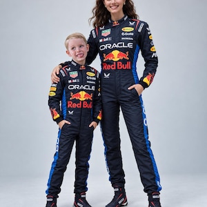 May include: Two matching dark navy blue and bright blue racing jumpsuits featuring the Oracle Red Bull Racing logo, the Red Bull bull graphic, and various sponsor logos including TAG Heuer, Mobil 1, Honda, and Sparco, paired with black racing boots.