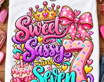 Könnte beinhalten: Ein weißes T-Shirt mit einer bunten Grafik und dem Schriftzug Sweet Sassy and Seven. Das Design zeigt eine goldene Krone, eine rosa Schleife mit Punkten, eine Geburtstagstorte mit brennender Kerze und eine große rosa Sieben mit bunten Streuseln.