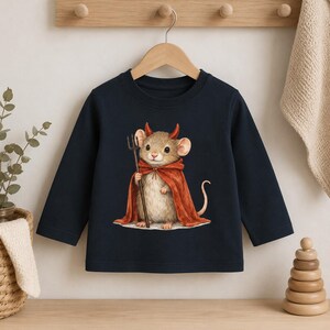 May include: A dark navy blue long-sleeve shirt featuring a graphic print of a light brown mouse wearing a red cape and small red devil horns. The mouse is holding a black trident in its right paw. The shirt has a round neckline and long sleeves.