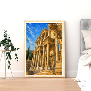 May include: A framed wall art print depicting the ancient Library of Celsus in Ephesus, Turkiye. The image features golden-hued stone columns and architectural ruins against a bright blue sky with white clouds. The text reads EPHESUS TURKIYE.