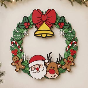 Puede incluir: Una corona navideña decorativa con un diseño en capas que incluye follaje verde, una campana amarilla grande con un lazo rojo, bastones de caramelo, bayas rojas, copos de nieve blancos, adornos verdes, dos figuras de jengibre, Santa Claus y un reno.