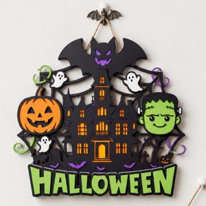 Può includere: Una decorazione da parete per Halloween in legno a strati con una casa stregata nera, una grande zucca arancione, una testa di mostro di Frankenstein verde, fantasmi bianchi e un pipistrello nero. La parola HALLOWEEN è scritta in lettere verdi.