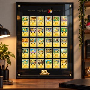 Op de afbeelding: Een ingelijste zwarte poster met een raster van dertig individuele Pikachu-ruilkaarten. Bovenaan in het midden staat de tekst Pokémon 30 Years of Pikachu, terwijl onderaan in het midden een gouden 30th Celebration-logo is afgebeeld.