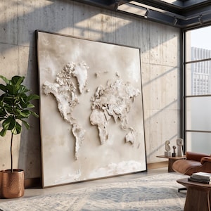 Può includere: Una grande opera d'arte murale quadrata che presenta una mappa del mondo in rilievo tridimensionale e testurizzata. I continenti sono resi in tonalità bianco sporco e crema, su uno sfondo beige neutro e tenue all'interno di una cornice sottile.