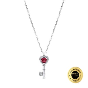 Può includere: Una collana color argento con un ciondolo a forma di chiave. La testa della chiave è una pietra rossa a forma di cuore circondata da piccole pietre chiare. Il gambo della chiave è composto da pietre chiare rettangolari e l'ingranaggio è un piccolo quadrato.