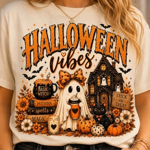 Peut inclure: Un t-shirt crème avec une impression graphique portant le texte "HALLOWEEN vibes". Le motif comprend un fantôme avec un nœud, un chat noir, des citrouilles, une maison hantée, des livres étiquetés "BASIC WITCH", "POTIONS", "spells", "MAGIC" et une bougie.