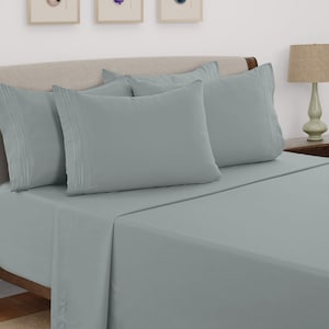 May include: A solid light gray bed sheet set featuring a flat sheet, a fitted sheet, and two pillowcases. Each pillowcase is designed with three horizontal stitched lines near the opening, providing a clean and uniform appearance.
