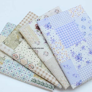 May include: Five fabric swatches featuring floral and geometric patterns in shades of blue, green, and beige. The fabrics are arranged in a stack, with the top fabric being a light blue and white patchwork design.